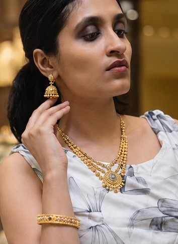 A temple jhumka and layered kasumala, worn